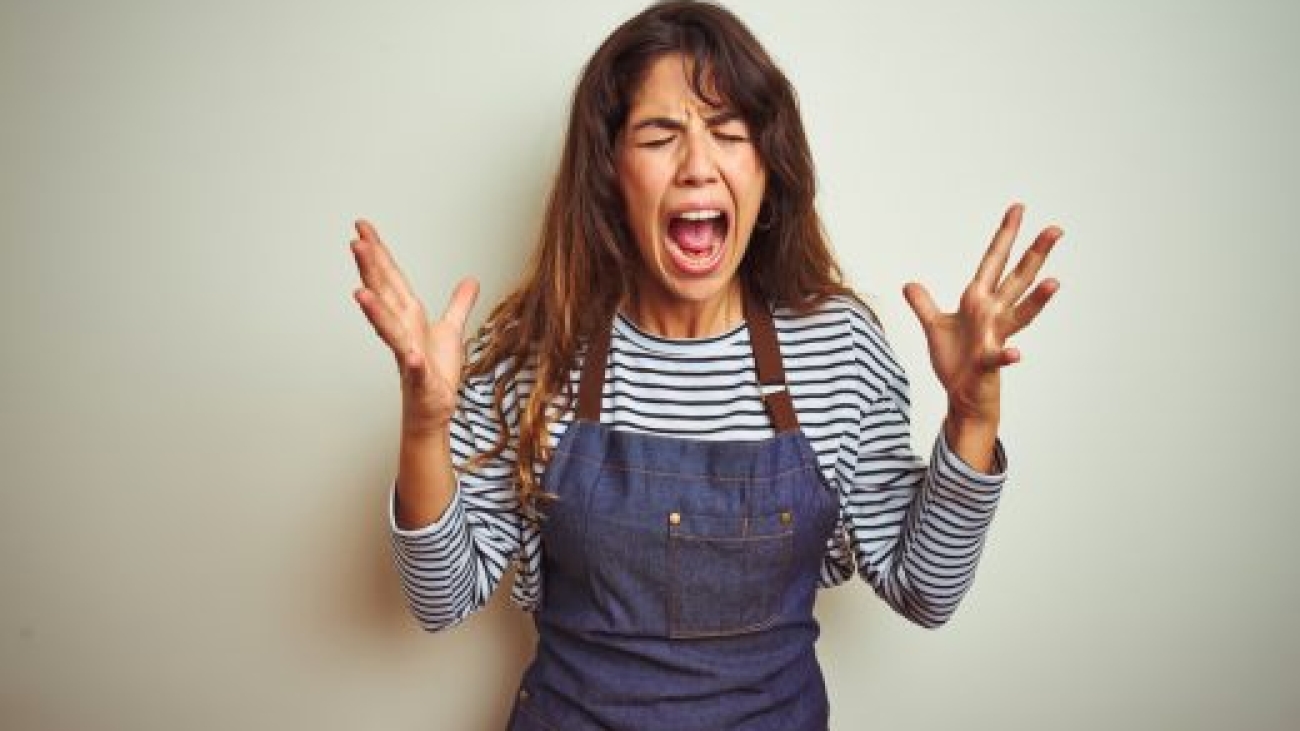 Young beautiful chef woman wearing apron cooking over white isolated background celebrating mad and crazy for success with arms raised and closed eyes screaming excited. Winner concept