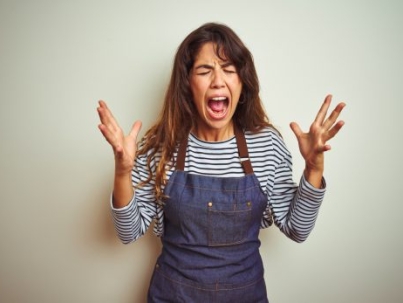 Young beautiful chef woman wearing apron cooking over white isolated background celebrating mad and crazy for success with arms raised and closed eyes screaming excited. Winner concept