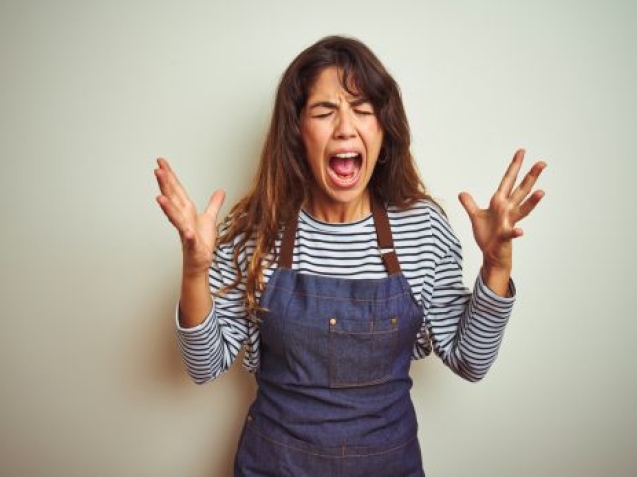 Young beautiful chef woman wearing apron cooking over white isolated background celebrating mad and crazy for success with arms raised and closed eyes screaming excited. Winner concept