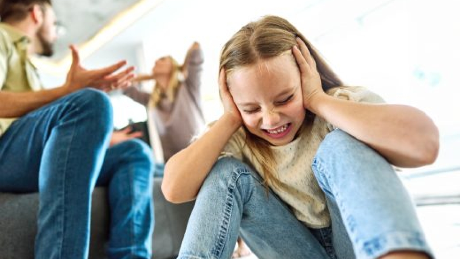 Portrait of a sad little girl and parents in conflict, disagreement or fight in the living room at home. Family, divorce and husband in argument with wife and unhappy child  in depression